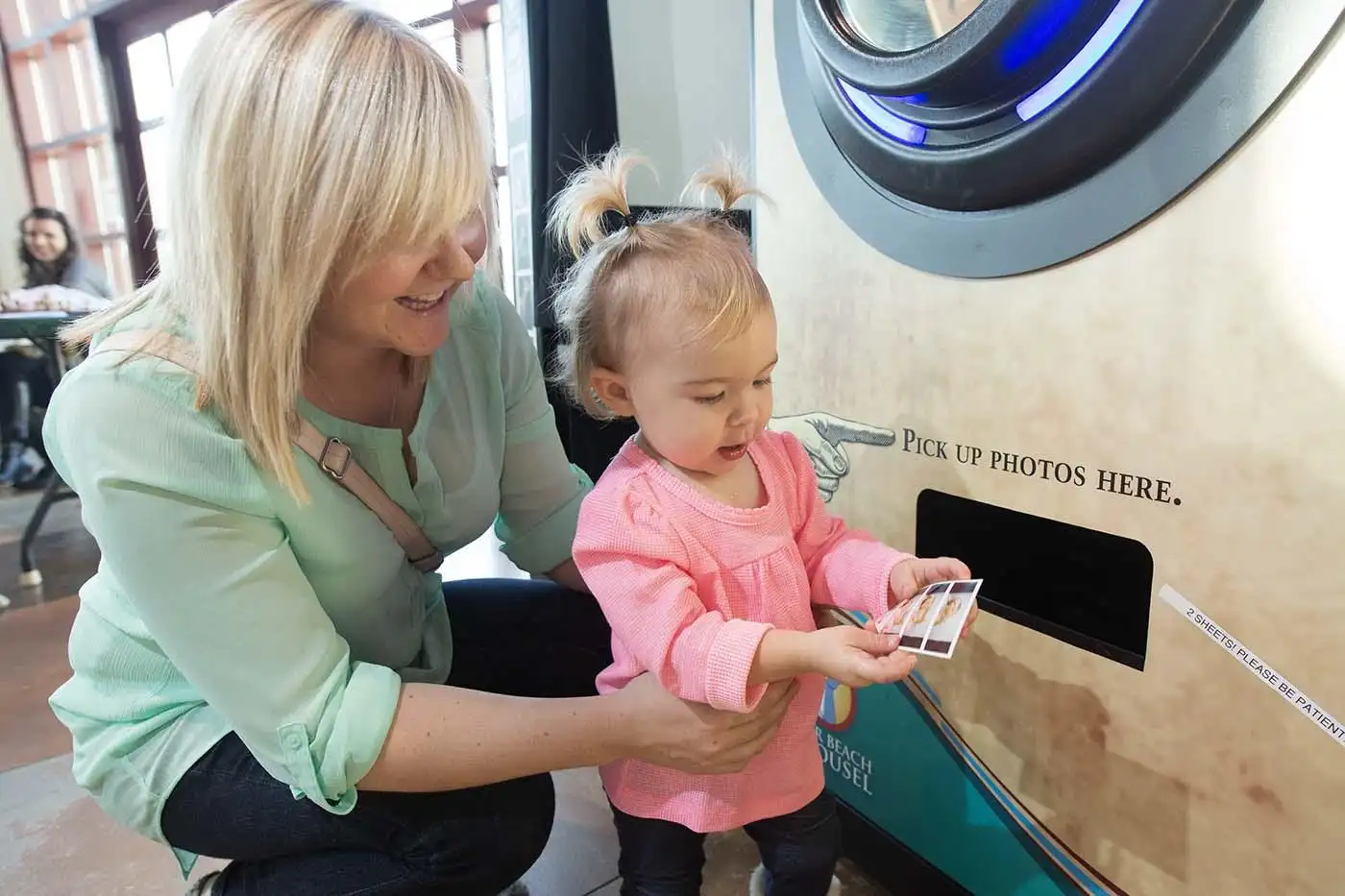 A mother and child looking at photos from the photo booth.